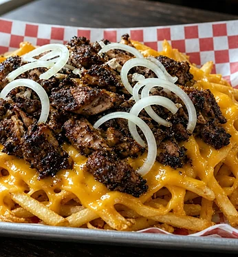 Jerk chicken cheese fries on checkered paper
