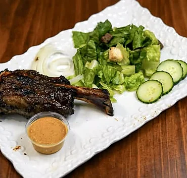 Smoked lamb shank on a white platter