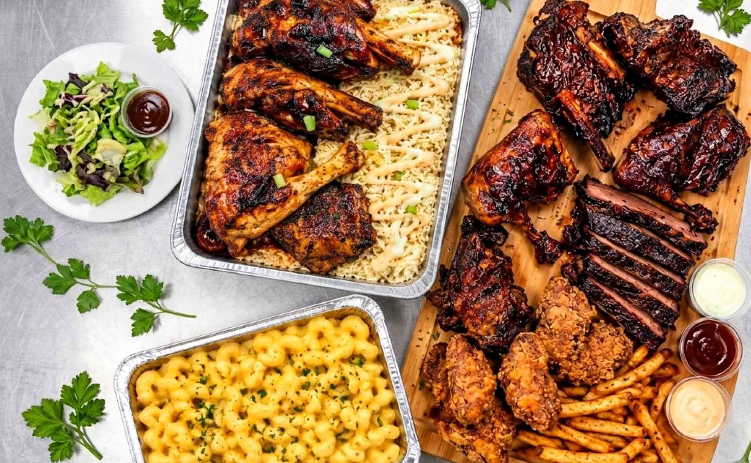Halal BBQ spread of ribs, sliced brisket, smoked chicken quarters on rice, fried chicken, fries, mac and cheese and salad